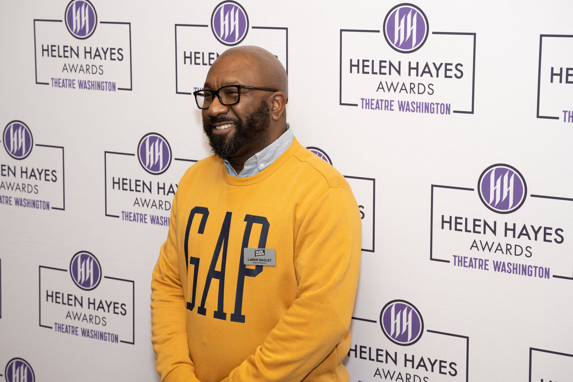 lamar bagley in front of a helen hayes awards backdrop